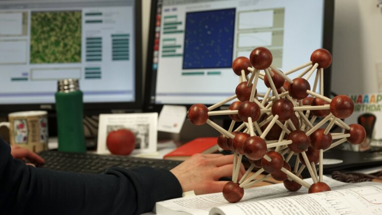 Computer screens and a wooden cluster model
